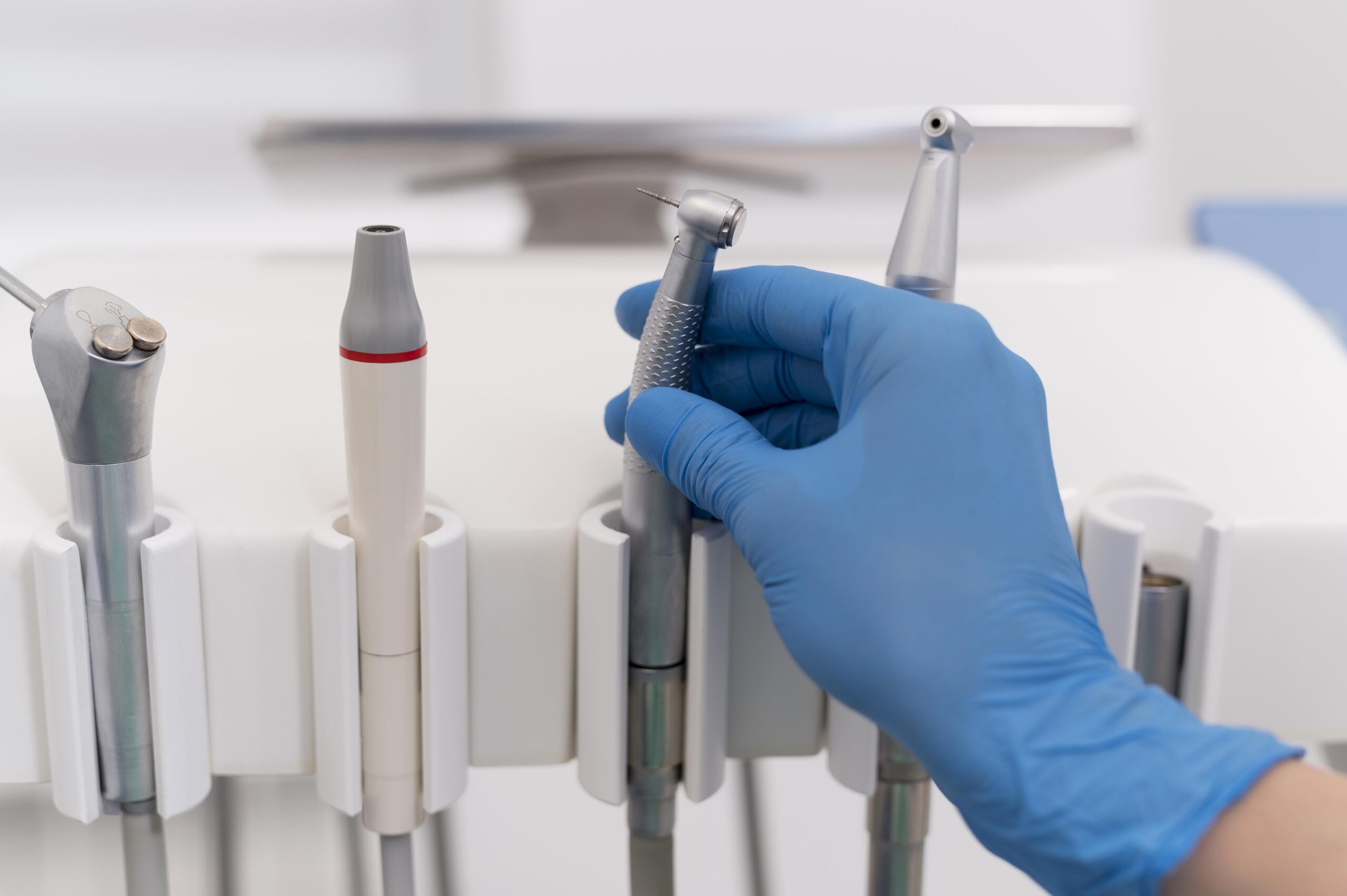 orthodontist with latex glove handling dental equipment